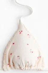 Top de bikini de triángulo de color crudo con pequeño estampado floreado y ribete fruncido en los bordes. Cuenta con tiras para anudar en la espalda y en el cuello.
