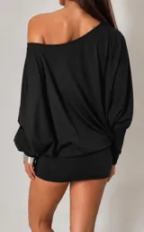 Vestido corto negro de estilo asimétrico con un hombro al descubierto y mangas largas. Presenta un diseño holgado en la parte superior y ajustado en la falda, con un cinturón de tachas metálicas incorporado.