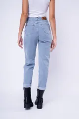 Pantalón de jean estilo mom fit, de tiro alto y corte recto con ruedo doblado. Presenta un lavado claro, cierre frontal con botón y bolsillos laterales y traseros.