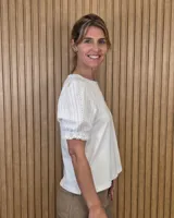 Remera blanca con cuerpo de algodón y mangas cortas abullonadas de broderie, con cuello redondo.