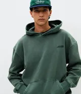 Hoodie de algodón verde con efecto acid wash, corte boxy, capucha y gran bordado en relieve con la palabra "horizon" en la espalda.