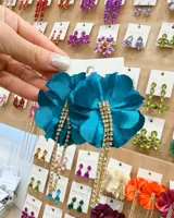 Aros colgantes con forma de flor de tela color turquesa y strass colgantes.