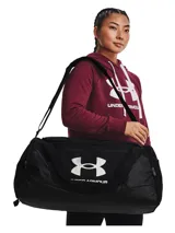 Bolso deportivo Under Armour Undeniable 5.0 Medium, color negro con el logo de la marca en blanco. Cuenta con tecnología UA Storm resistente al agua, compartimento principal con cierre, bolsillo ventilado para ropa sucia o calzado, bolsillos laterales para botellas y correa de hombro ajustable y acolchada.