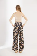 Pantalón de brocato con estampado de hojas de ginkgo en tonos azulados y beige, tiro medio y piernas rectas.