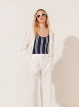 Body negro con rayas verticales blancas, escote redondo y breteles anchos.