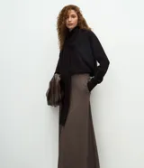 Falda midi de corte evasé con estampado de cuadros pequeños en tonos marrones. Presenta una cintura lisa de sastrería y un diseño estructurado que aporta fluidez al movimiento.