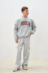 Pantalón de jogging gris melange de corte ancho, con bolsillos laterales y detalles de costuras blancas a contraste.