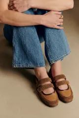 Chatita de cuero color camel, con detalles en gamuza al tono en la puntera y el talón. Presenta doble tira con cierre de velcro en el empeine y suela de goma dentada.