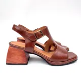 Sandalias de cuero color marrón con diseño de tiras anchas, hebillas metálicas doradas y taco ancho de madera de 4.5 cm.