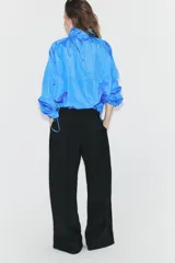 Pantalón de tiro alto con diseño cruzado tipo pareo en el frente, pernera ancha y caída fluida.