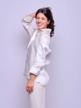 Camisa de lino color celeste, de manga larga, con cierre frontal de botones y cuello camisero.
