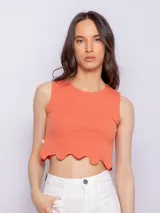 Top color salmón sin mangas, con cuello redondo y terminación ondulada en el ruedo.