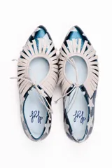 Zapato tipo blucher de cuero con acabado metalizado en color azul petróleo y estampado de estrellas blancas. Presenta un diseño con flecos decorativos en la parte frontal, cierre con cordones y suela plana de cuero.