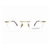Lentes de lectura con armazón al aire, chapados en oro de 18k. Presentan un diseño minimalista con puente y patillas metálicas doradas y terminales de acetato oscuro.