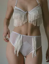 Sustén de seda color blanco con diseño sin copa, detalle de flecos tejidos a mano en tres filas y tirantes ajustables.