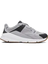 Championes Under Armour Forge 96 Reissue, inspirados en el diseño de 1996, combinan malla y cuero nobuk en color gris con detalles en negro, entresuela blanca y suela de goma marrón.