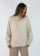 Sweater de punto en color beige, con cuello redondo, mangas largas con puños acanalados y diseño holgado.