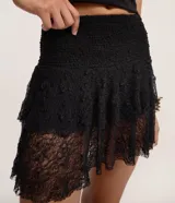 Short pollera negro de encaje con textura, cintura elástica y doble capa de volados.
