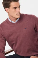 Suéter de tejido fino color azul marino, con cuello en V y manga larga. Presenta un pequeño logo bordado en el pecho.