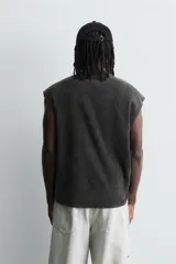 Camiseta sin mangas (tank top) de algodón con efecto lavado oscuro, corte cropped y cuello redondo. Presenta un estampado frontal en blanco con varios caballos en estilo gótico y texto en la parte inferior.