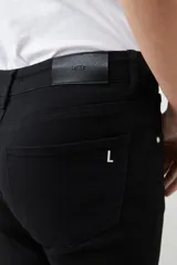 Pantalón negro de corte recto, tiro medio y bolsillos delanteros y traseros.