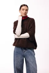 Sweater de tejido de punto grueso con silueta amplia y mangas 3/4. Presenta un diseño de calce relajado con cuello redondo y textura voluminosa.