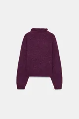 Jersey de punto con textura, cuello subido y manga larga, de corte recto y diseño clásico.
