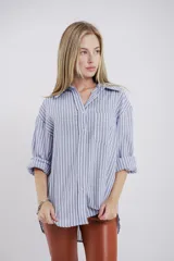 Camisa a rayas verticales grises y blancas, de corte recto y mangas largas.