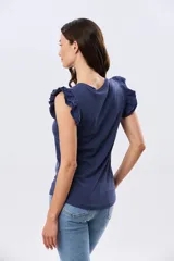 Remera de algodón azul melange con escote redondo y mangas cortas adornadas con doble volado de broderie en los hombros.