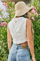 Top blanco de broderie con cuello halter y detalles de volados en el cuello y el ruedo.
