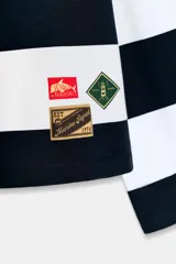 Camiseta de manga larga con cuello redondo, confeccionada en algodón, con patrón de rayas horizontales anchas en azul marino y blanco. Presenta dos etiquetas rectangulares cosidas en la parte inferior delantera.