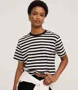Remera oversized de algodón con rayas horizontales blancas y negras, cuello redondo y mangas cortas.