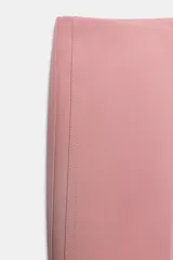 Pantalón de vestir color rosado, tiro bajo, con corte acampanado (flare) y costuras laterales marcadas. Cierre frontal con botón interior y gancho.