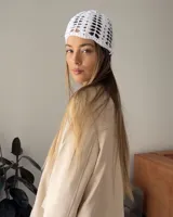 Casquete tipo gorro de crochet blanco, tejido a mano con hilo de algodón, con diseño de red o calado.