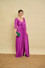 Vestido largo bordó de fiesta, con escote en V pronunciado, nudo drapeado en la cintura y tajo frontal. Las mangas son tres cuartos en tul translúcido con detalles sutiles.