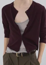 Cardigan de punto fino color bordó, de diseño recto, con cuello redondo, manga larga y cierre frontal con botones.