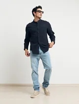 Camisa de cuello mao y manga larga, confeccionada en una mezcla de lino y algodón. Presenta un diseño de corte recto con botones en tono natural y un bolsillo pequeño en el pecho.