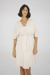 Bata maternal de algodón suave con diseño envolvente, escote en V y lazo ajustable en la cintura. Presenta mangas cortas holgadas y una silueta adaptable ideal para el embarazo y la lactancia.