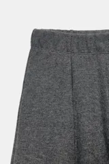 Pantalón de tiro alto con pierna ancha y cintura elástica ajustable. Presenta un diseño de corte holgado con costuras verticales frontales que definen su silueta.