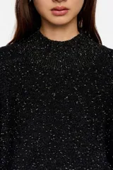 Sweater de punto negro con efecto tweed o neps en color dorado/amarillo claro, cuello alto tipo caja y mangas largas. Corte recto y holgado.
