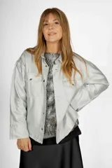 Sobrecamisa de lamé color celeste, con cuello camisero, botones frontales y bolsillos con solapa en el pecho.