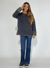 Sweater gris de manga larga con cuello redondo y puños con detalle de volados de lana rizada.
