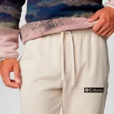 Pantalón de jogging Columbia modelo Beaumount, de color beige con puños elásticos en los tobillos y bolsillos laterales. Cuenta con el logo de la marca bordado en la pierna izquierda.