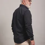 Camisa de vestir celeste a rayas verticales blancas, de corte clásico, con cuello abotonado y manga larga.