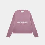 Sweater de tejido punto color rosa, con cuello redondo y corte oversize. Presenta un estampado frontal con el texto "EME STUDIOS" y debajo "curated by ben ice".