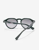 Gafas de sol unisex Hawkers edición limitada Alex Rins, con montura redonda color verde oscuro y lentes degradadas grises.