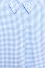 Camisa de manga larga con cuello solapa y cierre frontal de botones, confeccionada en tejido de algodón con estampado de cuadros vichy en tonos azul y blanco.