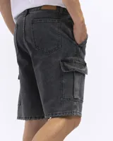 Bermuda de jean azul oscuro, estilo cargo, con bolsillos laterales con tapa a la altura del muslo.