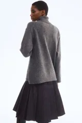 Buzo de punto suave con cuello alto acanalado, diseño de corte holgado, hombros caídos y terminaciones acanaladas en puños y bajo.