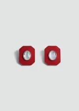 Par de aros tipo botón con forma geométrica octogonal, color rojo con borde plateado y cristal ovalado en el centro.